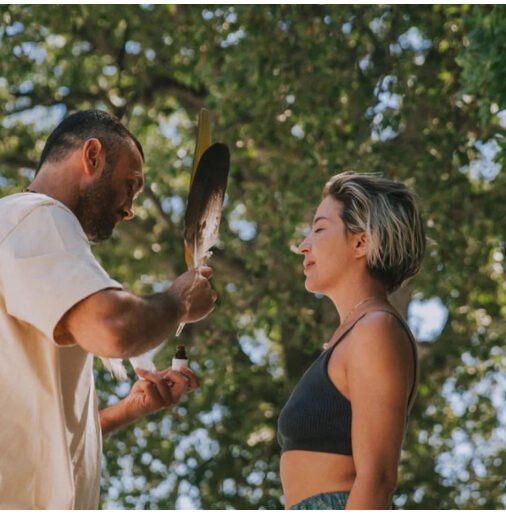 omprakash doing a blessing with feathers to a woman